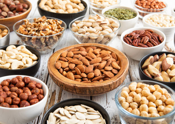 istock Mixed raw nuts and seeds in bowls on kitchen table.Peanut,hazelnut,walnut,almonds,pistachio,sunflower,pumpkin,chia and cashew.Macro 2166719572
