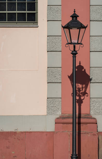 Germany, Potsdam, August 10, 2024 - Old lantern with shadow against a house wall