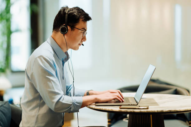 istock Asian businessman on videoconference with headset in modern office, capture the serious and contemplative emotions. 2166724487
