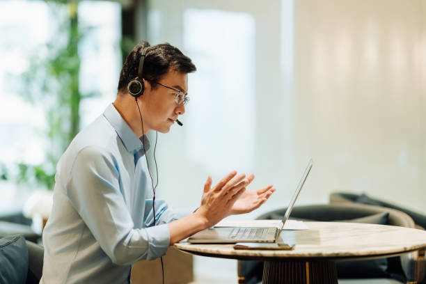 istock Asian businessman on videoconference with headset in modern office, capture the serious and contemplative emotions. 2166724513