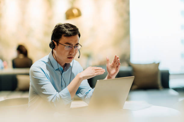 istock Asian businessman on videoconference with headset in modern office, capture the serious and contemplative emotions. 2166724544