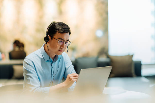 istock Asian businessman on videoconference with headset in modern office, capture the serious and contemplative emotions. 2166724548