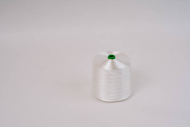 A spool of white fiberglass thread with a green top, displayed against a plain white background, showcasing the texture and weave of the material.