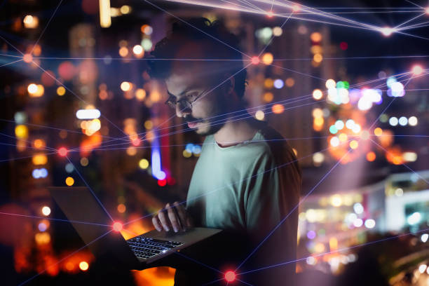 istock Man on Laptop with City Lights and Digital Web Overlay 2166728712