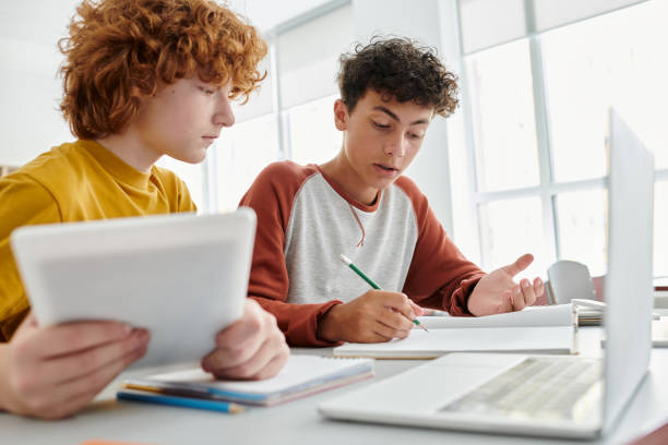 istock Teenage students collaborating on a project in a bright and modern classroom at school 2166731266