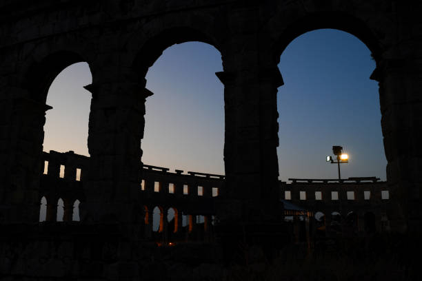 Inside the Pula Arena in Croatia with illuminated facade at night.