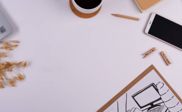 Office desk with empty place on paper, smart phone with device sreen and black coffee cup. Office supply on white background. Place of work.