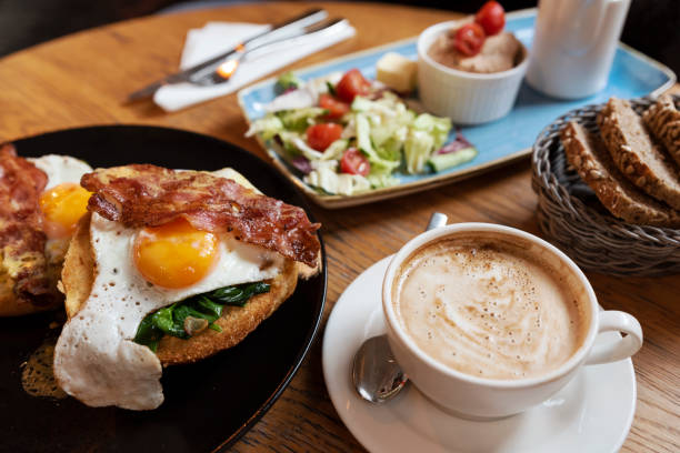 food and drink ready to eat for breakfast in restaurant. fried egg on sandwich with cappuccino. healthy eating. - sarapan hidangan foto potret stok, foto, & gambar bebas royalti