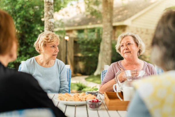 Senior friends sitting in the backyard. They are having coffee, dessert and drinks together. Part of a series where we follow a group of seniors living in the larger Houston area, Texas.