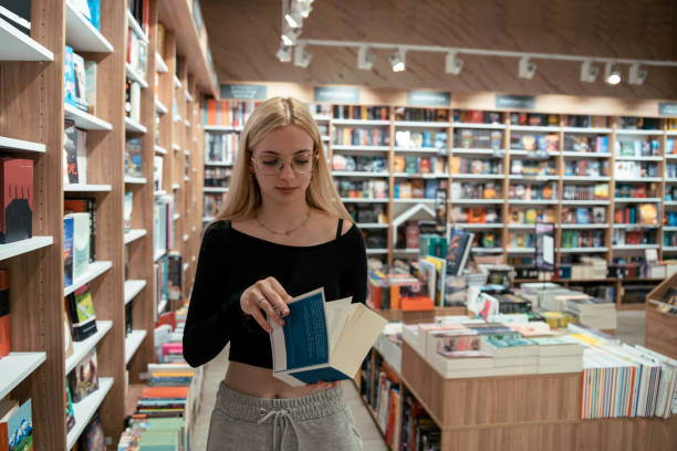Pretty  young woman in the bookstore looking for the books