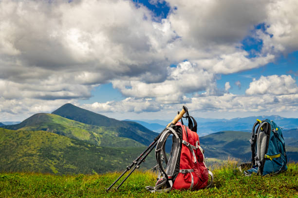 Hiking in the mountains with a backpack and walking poles.