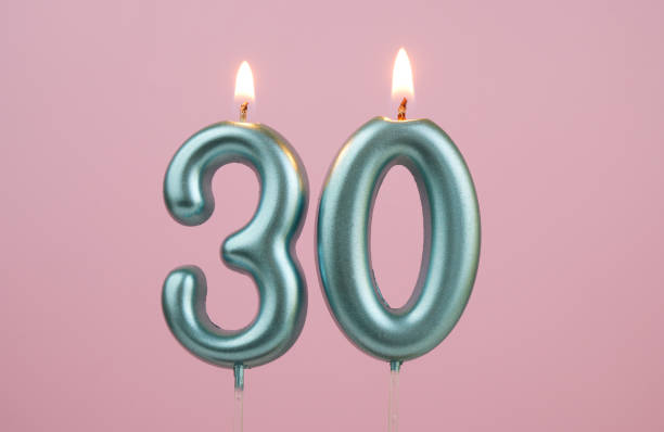 istock Blue birthday candles on pink background, number 30 2166741096