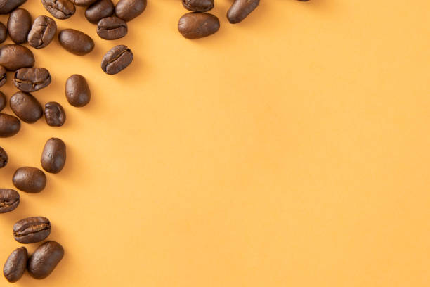 Coffee beans on yellow background with copy space