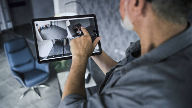istock Male installer watches CCTV cameras in stylish office using tablet computer 2166741590