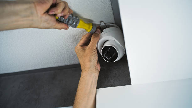 istock Professional male technician attaches security camera to the ceiling 2166742233