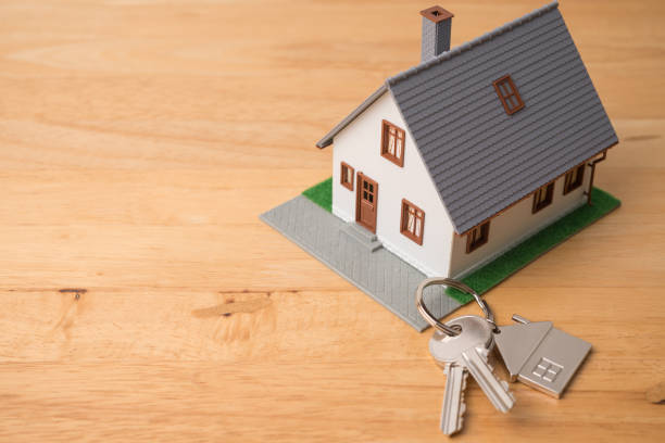 istock House model and key on wooden table background with copy space. 2166743063