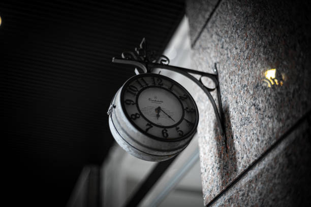 Clock on the wall of a building. Selective focus. Toned.