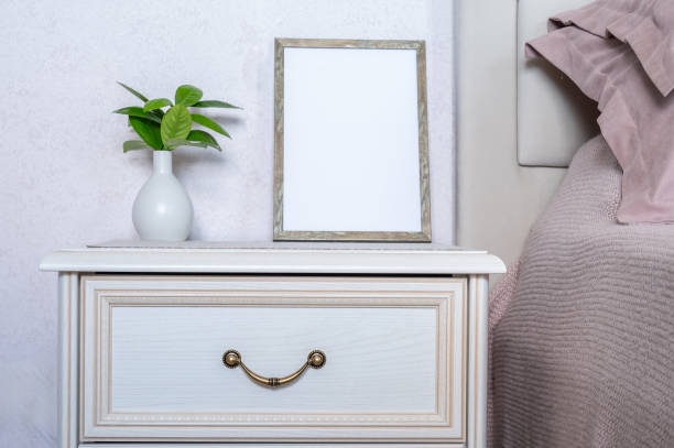 istock Template with photo frame on a bedside table. Bouquet of tangerine tree branches. Sunlight from the window. Copy space. 2166745935