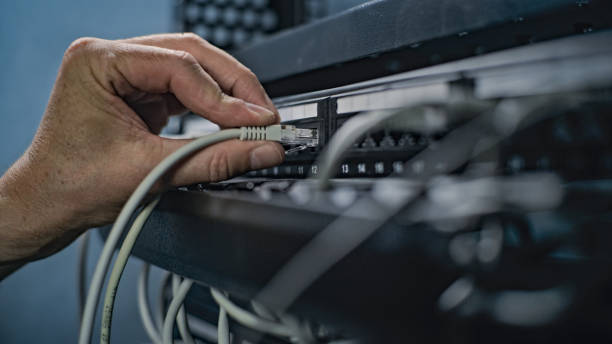istock Close up of system administrator connecting cables with server rack 2166746158