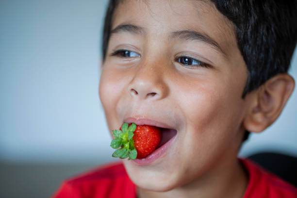 istock Little boy eating strawberries 2166746443