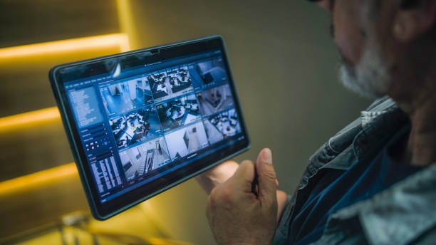 istock Male installer watches CCTV cameras in stylish office using tablet computer 2166746926