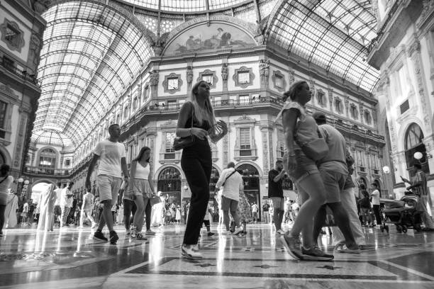 Milan, Italy - 2024, July 30 : People walking inside the elegant Galleria Vittorio Emanuele, an antique shopping arcade in the historic old town of Milan right next to the Duomo - monochrome