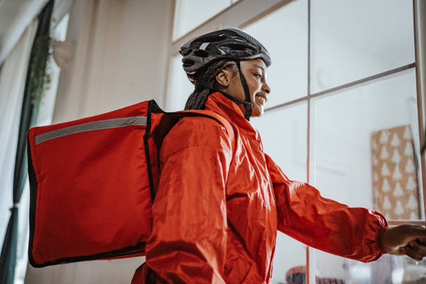 istock Delivery person opening door in red jacket, side view 2166748932