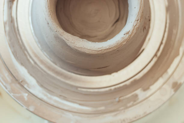 ceramics class, a man makes a clay plate on a potter's wheel