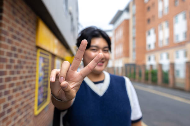 Photo of cheerful glad nice boy wear stylish yellow clothes showing v-sign symbol isolated on purple color background.