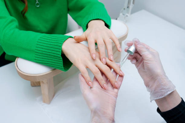 istock A woman is getting her nails done by a man 2166754814