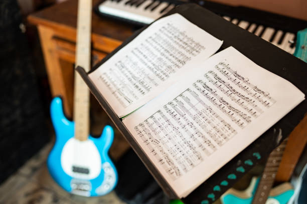 Directly Above Shot Of Guitar And Note Pad On Wooden Table
