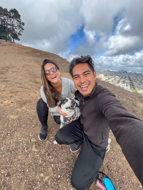 istock Happy Couple Taking Selfie with Dog on Hilltop 2166765331