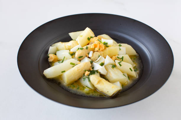 white asparagus salad with boiled egg on black plate