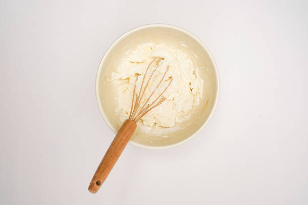 Raw dough with whisk for pastries and flour isolated on white background. Top view. Flatlay. High quality photo