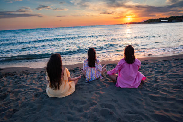 istock Three female friends meditating on the beach 2166770781