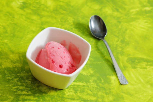 An Asian woman is enjoying scoops of ice cream in hotel buffet