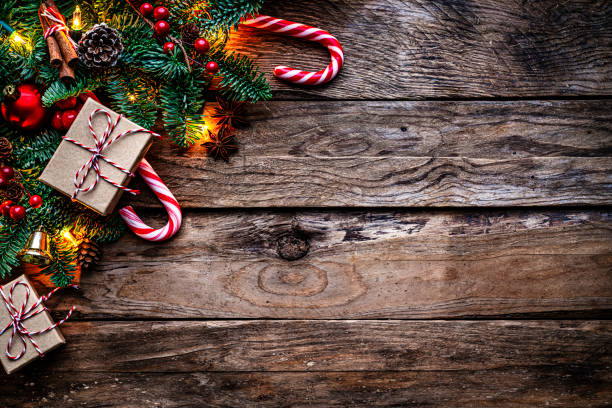 Christmas decor on old wood background with string lights, fir tree, Christmas presents and candy cane Copy space