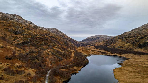 istock Serene landscape with a winding river through autumn-colored hills under a cloudy sky in Scotland. 2166779178