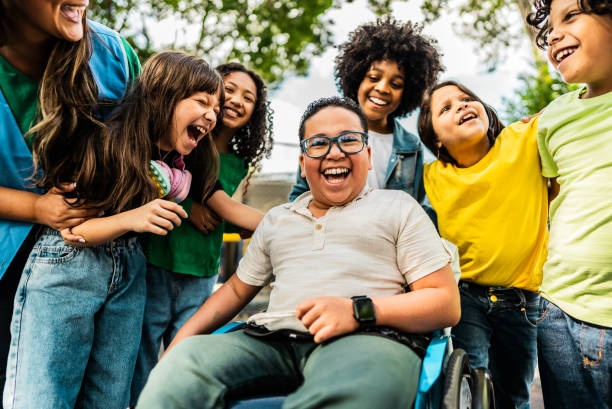 Happy students on schoolyard Happy students on schoolyard- including a wheelchair boy boy and girl looking at camera stock pictures, royalty-free photos & images