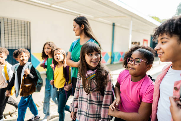 istock Teacher walking holding hands on schoolyard 2166780865