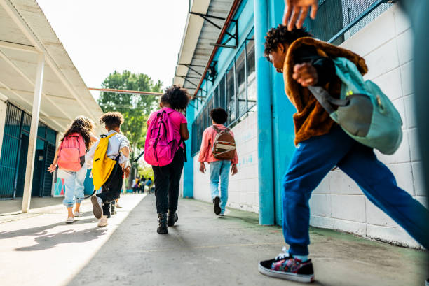 istock Rear view of students walking on schoolyard 2166781259