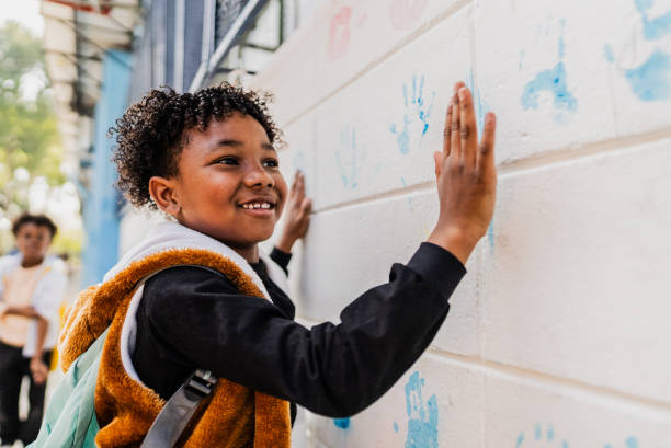 istock Schoolboy painting the wall with hands on schoolyard 2166781300