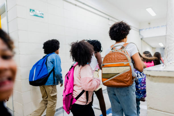 istock Rear view of students walking on corridor on school 2166782179