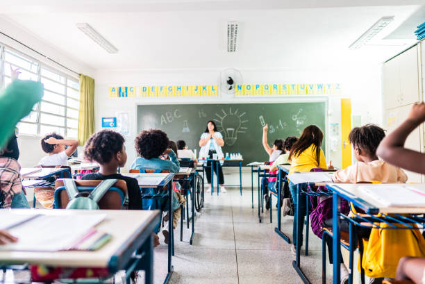 istock Rear view of students studying on classroom at school 2166782350