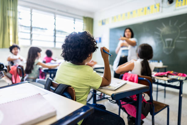 istock Rear view of a schoolboy studying on classroom at school 2166782683