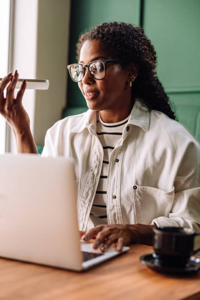istock Happy Black woman smiling while recording voice message 2166783510