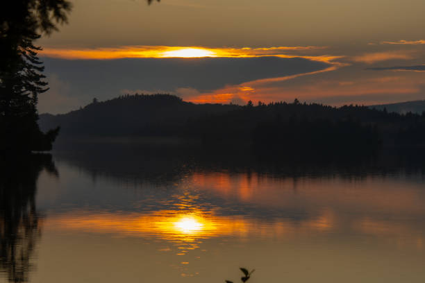 Sunset with reflection on a Swedish lake in Smalland. Romantic evening mood. Landscape shot from Scandinavia in nature