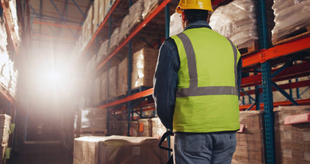 istock Inventory, box and man with trolley in warehouse for supply chain, packaging and logistics distribution. Dropshipping, supplier and packer with helmet by shelf for cargo picking, loading and delivery 2166784817