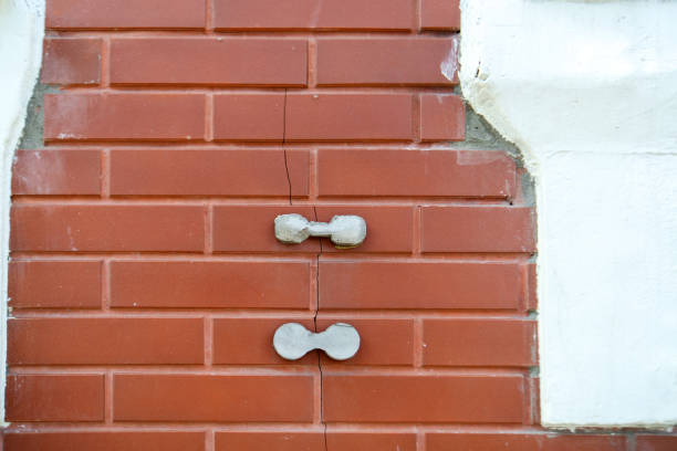istock striking image showcases concrete weights mimicking dumbbells, bridging a cracked brick wall. It symbolizes strength and resilience amid structural decay, merging fitness and architecture 2166785017