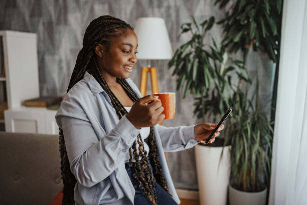 istock Woman enjoying coffee while using phone in living room 2166785589